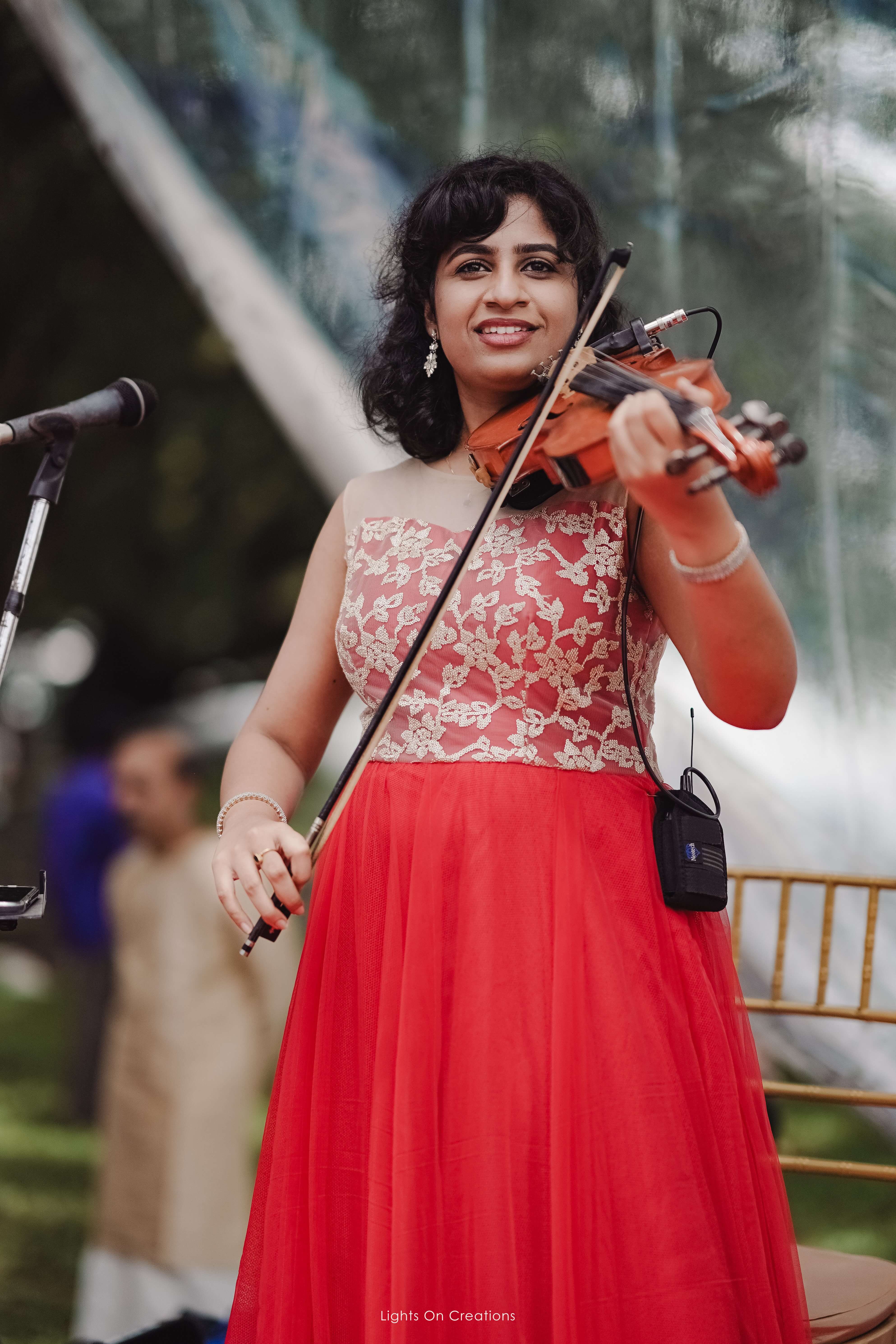 Outdoor violin performance in red lehenga